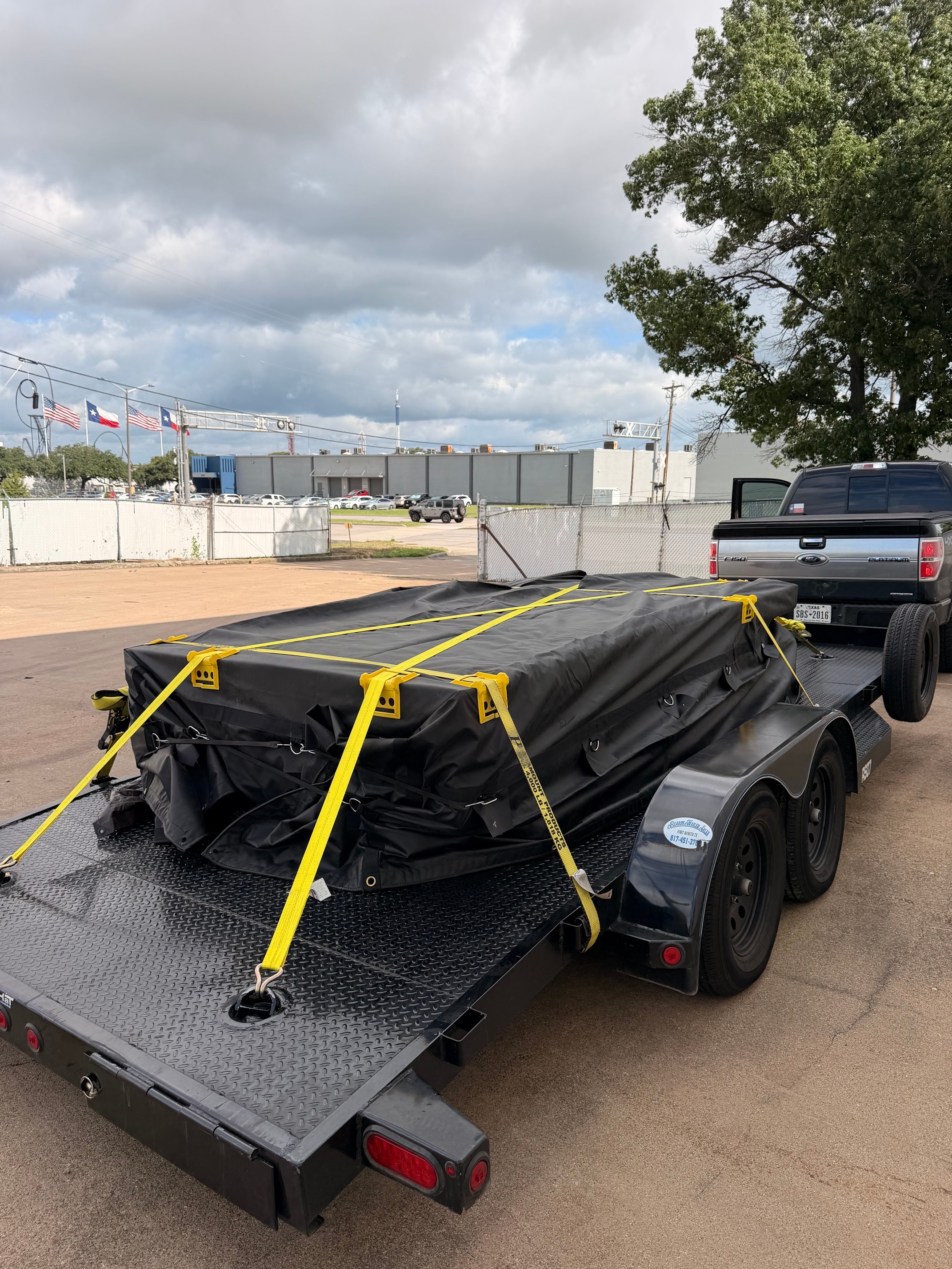 Covered load with yellow straps, Texas flags in background