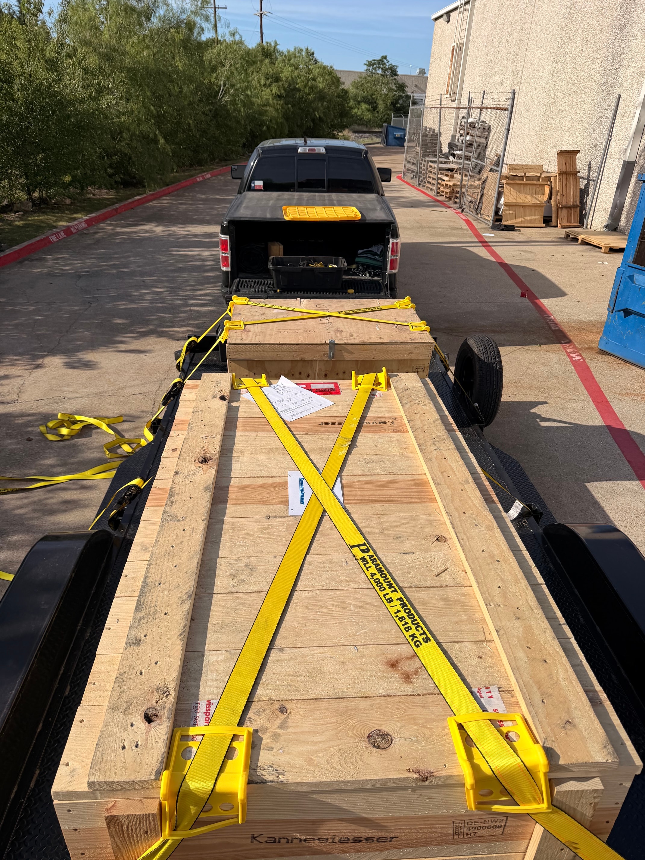Wooden crate strapped to flatbed trailer